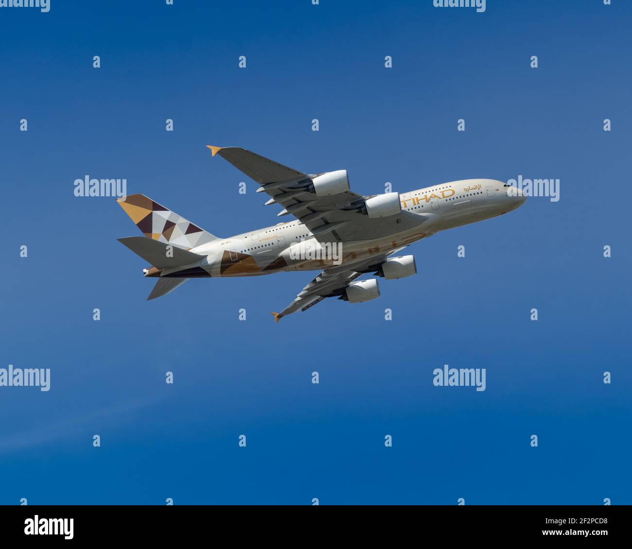 Londres, Heathrow Airport - Mars, 2020: Etihad Airways Airbus 380 Super Jumbo REG A6-APJ vol haut et bancaire à gauche par ciel bleu clair. Banque D'Images