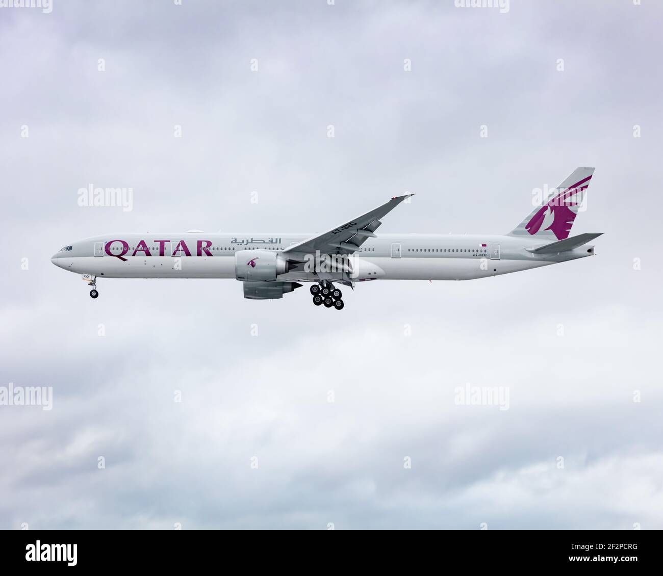 Londres, Heathrow Airport - Mars, 2020: Qatar Airways Boeing 777 en vol à travers une journée blanche mais nuageux à l'approche finale de Heathrow. Image AB Banque D'Images