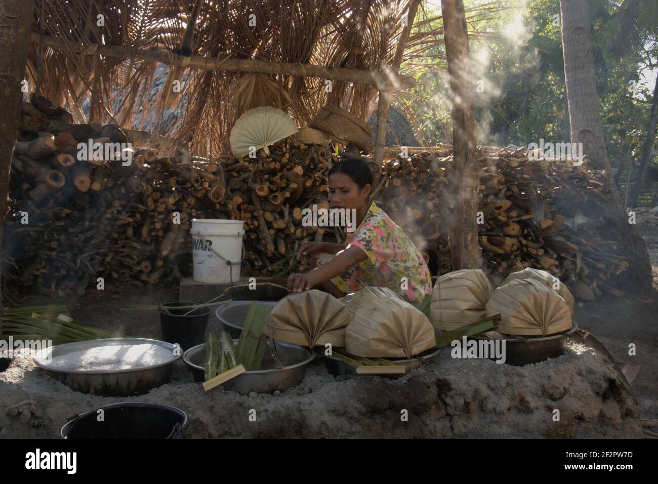 Yunce Unbanu faire bouillir la sève de palmier pour faire du sucre de palmier dans le village d'Oehandi, île de Rote, Indonésie. Banque D'Images