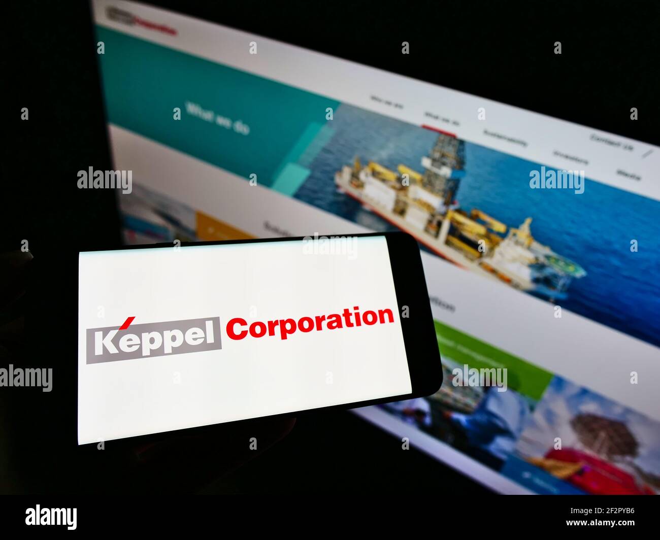 Personne tenant un smartphone avec le logo du conglomérat de Singapour Keppel Corporation à l'écran devant le site Web. Mise au point sur l'affichage du téléphone. Banque D'Images