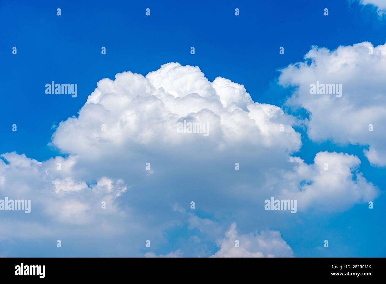 Nuage blanc géant flottant sur fond bleu ciel Banque D'Images
