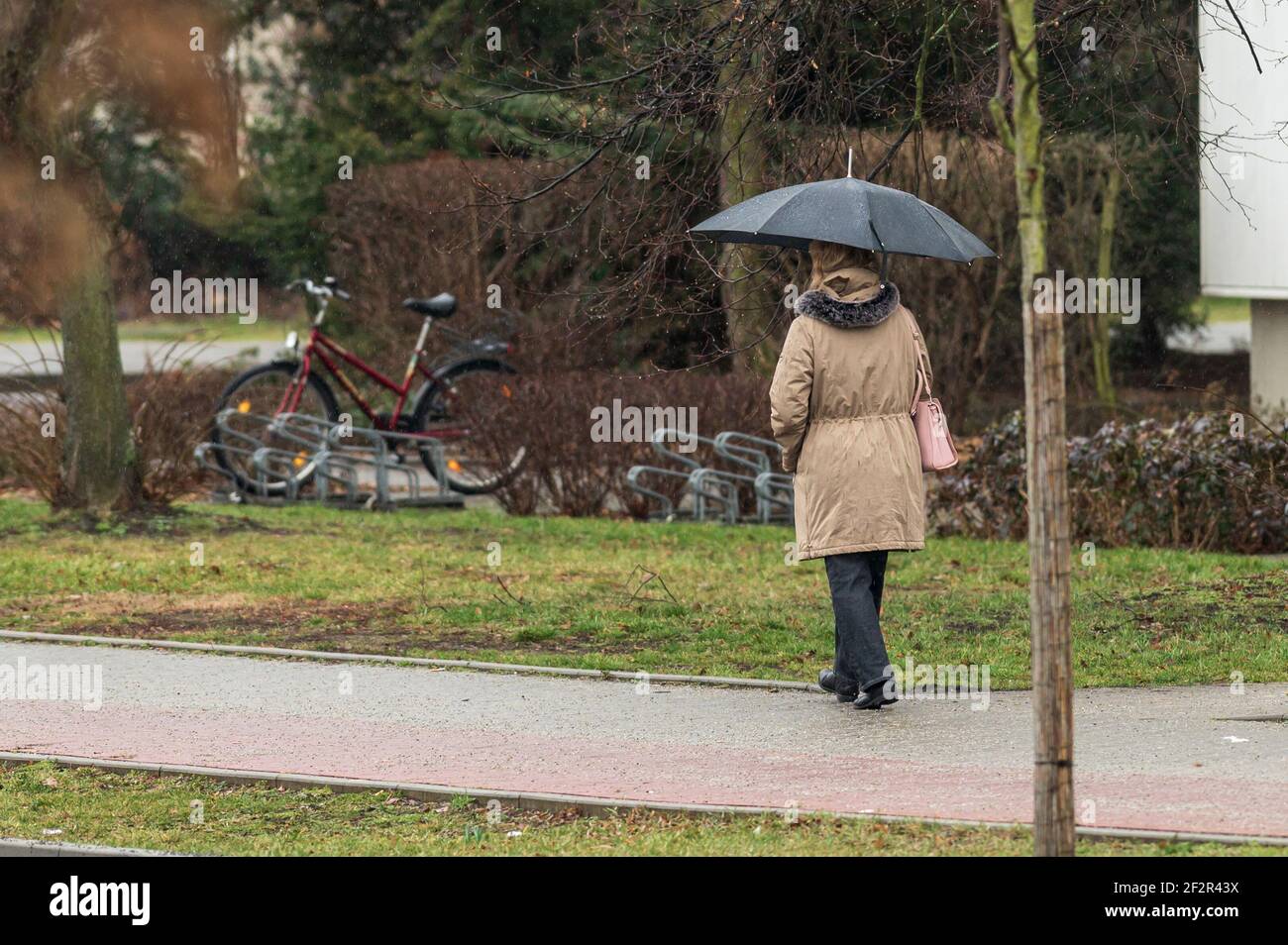 Femme avec parapluie sur le trottoir Banque D'Images