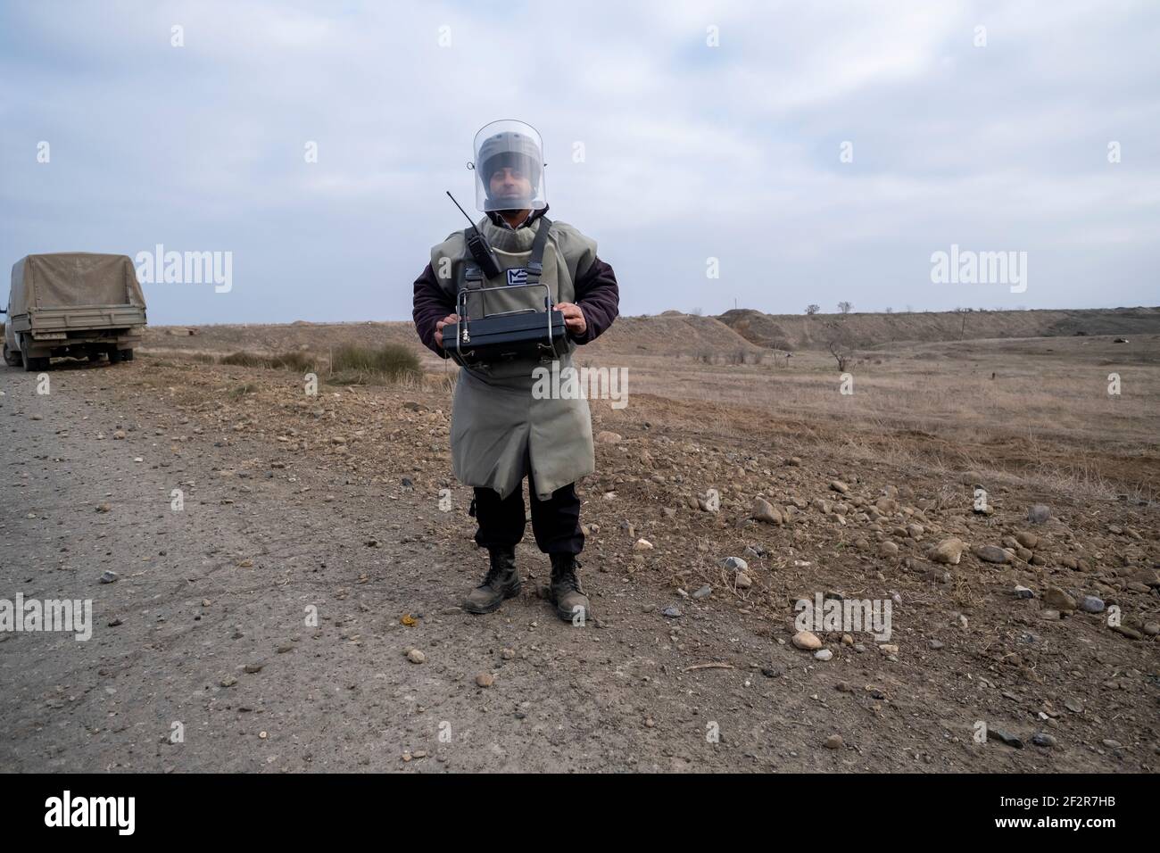 AGDAM, AZERBAÏDJAN - DÉCEMBRE 14 : un sapeur de l'Agence nationale azerbaïdjanaise pour l'action antimines (ANAMA) portant une combinaison de bombes se prépare à utiliser un véhicule de déminage sans pilote près de la ville d'Agdam qui a été capturé et détruit par les forces arméniennes ethniques en 1993, Lors de la première guerre du Haut-Karabakh le 14 2020 décembre à Agdam, en Azerbaïdjan. La ville d'Agdam et son district avoisinant ont été retournés sous contrôle azerbaïdjanais dans le cadre d'un accord qui a mis fin à la guerre du Haut-Karabakh de 2020. Peu de temps après le retour au contrôle azerbaïdjanais, la ville a commencé à être nettoyée. Il est prévu Banque D'Images