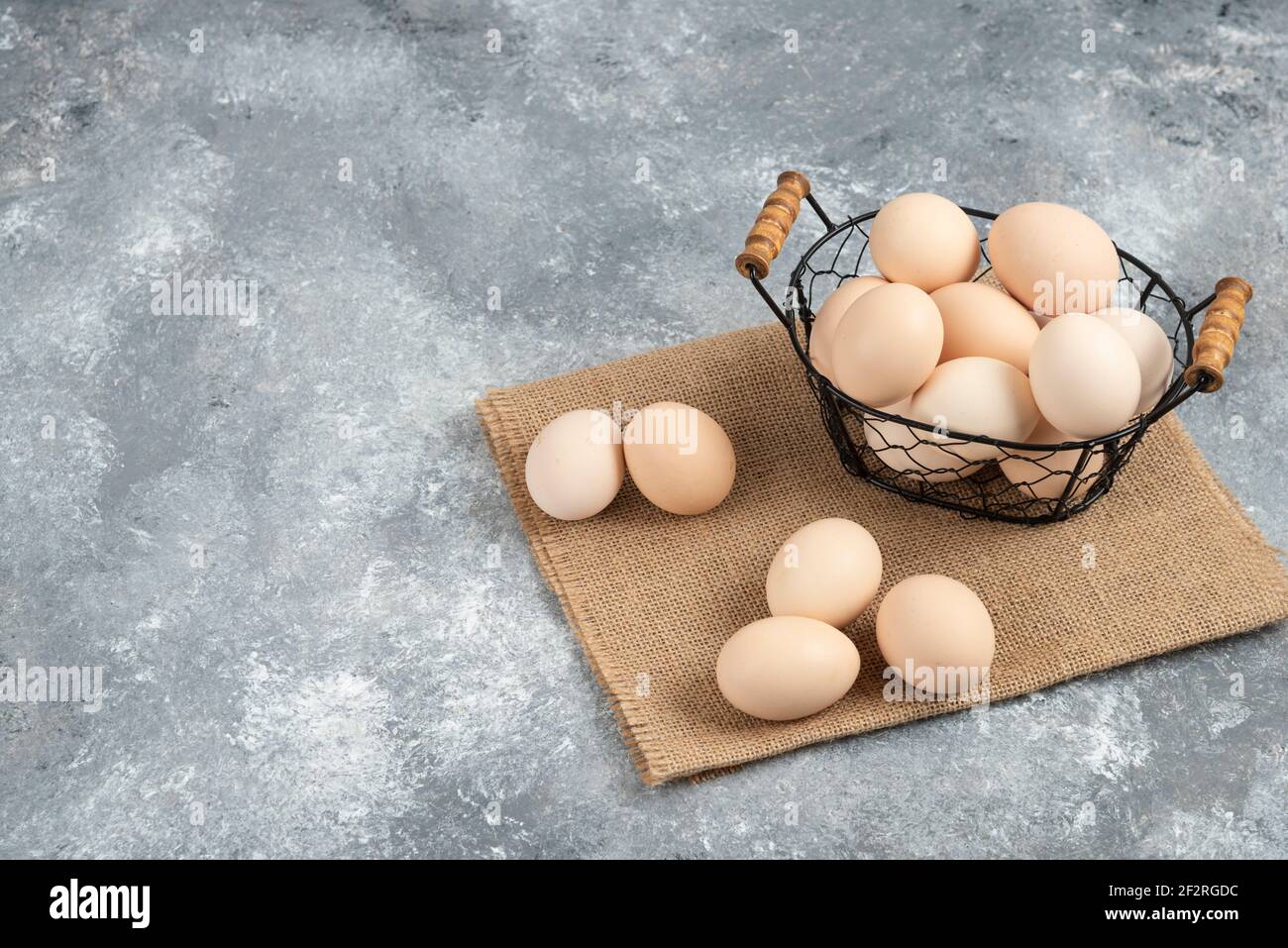 Panier en osier composé d'œufs biologiques crus sur fond de marbre Banque D'Images