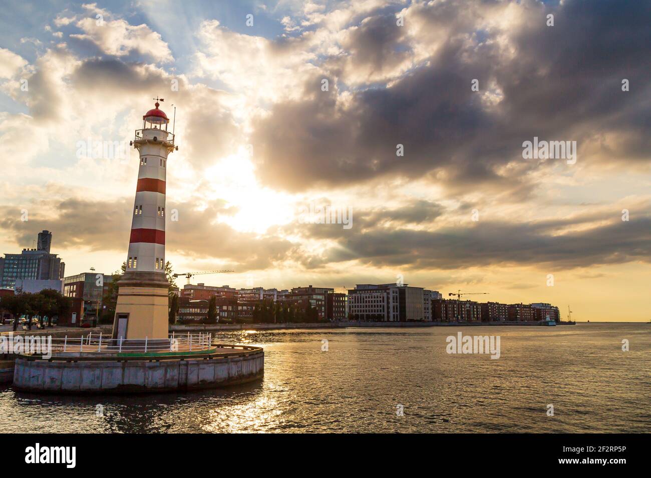 Phare rouge et blanc dans le port urbain de Malmö Suède pendant le coucher du soleil d'été Banque D'Images