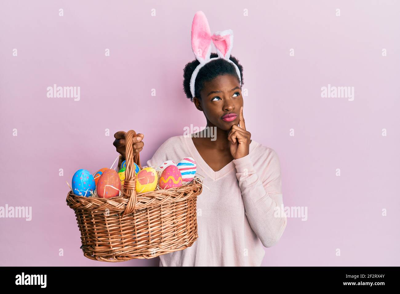 Joyeuses Pâques pour enfants Une fille aux cheveux bouclés vêtue d'un