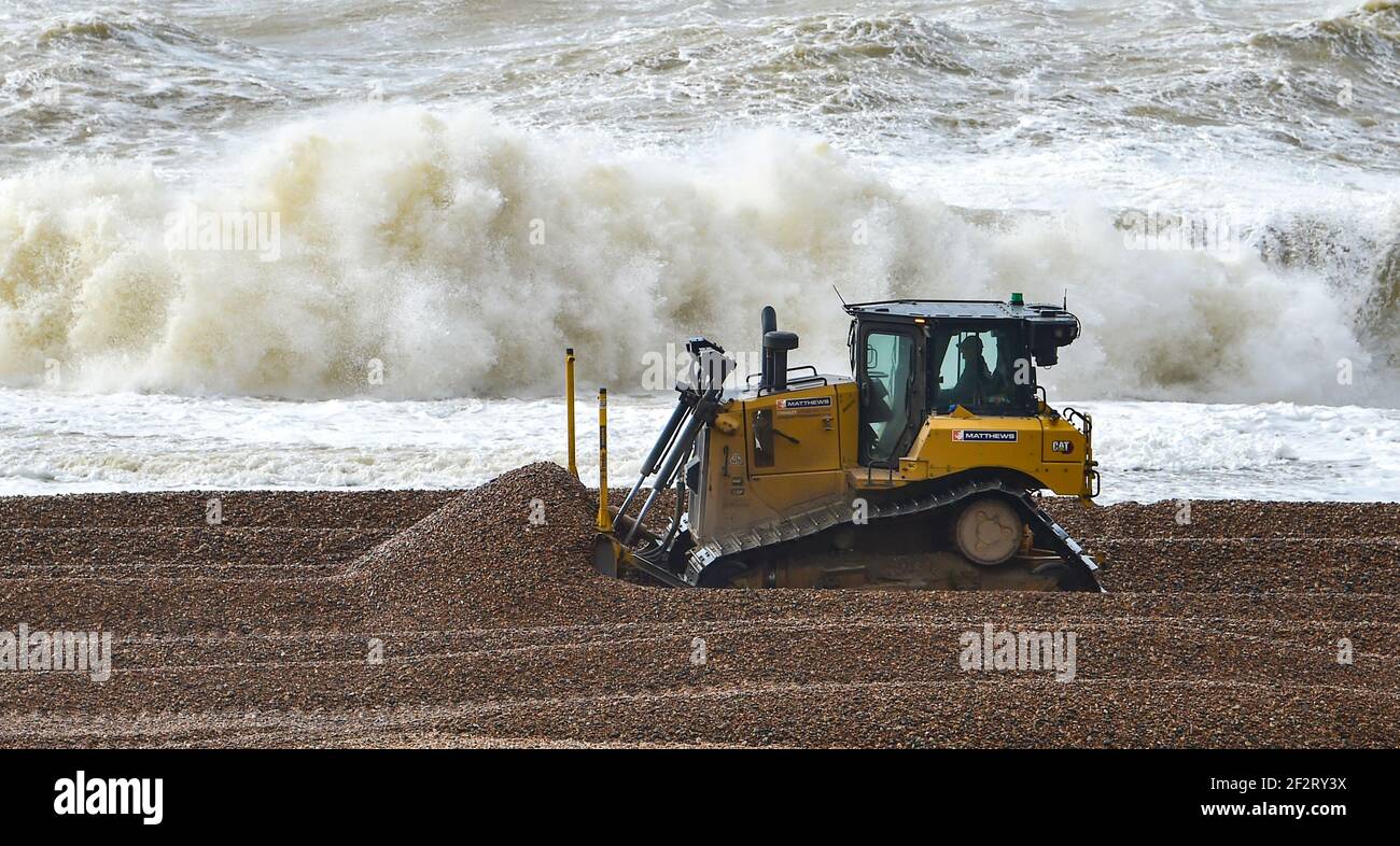 Brighton Royaume-Uni 13 mars 2021 - Workmen shift se mêlent le long de la plage par Brighton Marina comme de forts vents battent de nouveau la côte sud aujourd'hui : Credit Simon Dack / Alamy Live News Banque D'Images