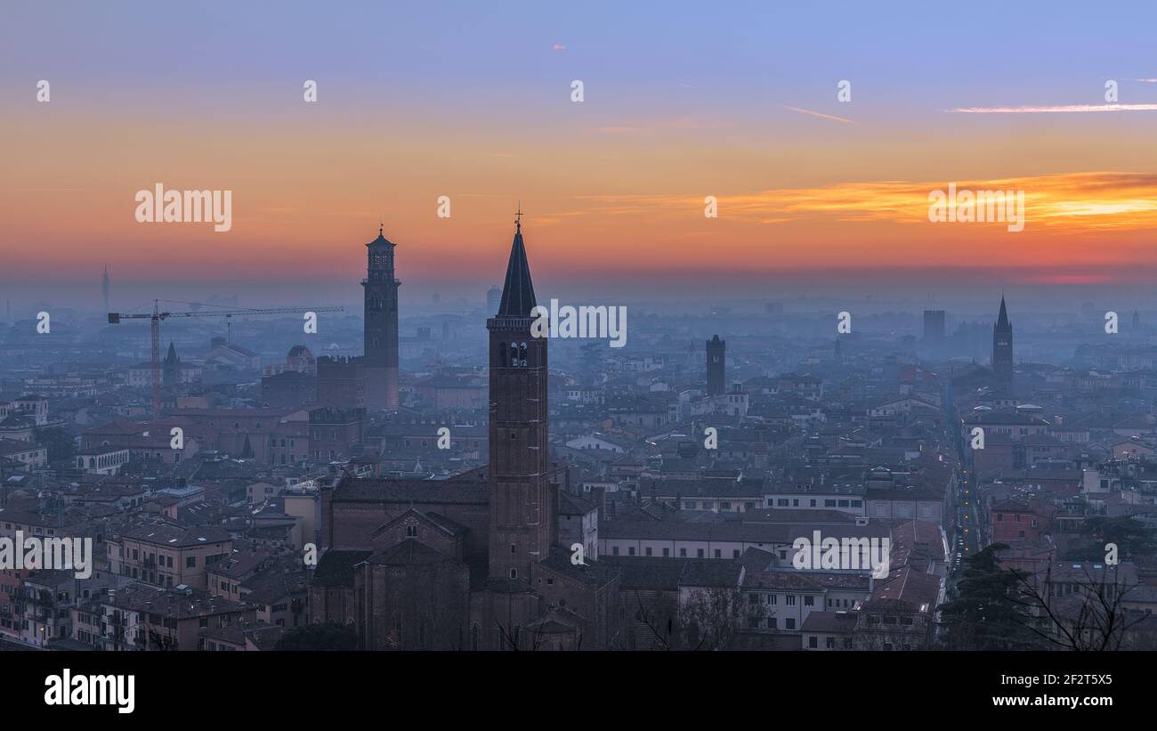 Magnifique vue panoramique sur le coucher du soleil de la vieille ville de Vérone, Torre Lamberti et le clocher de Santa Anastasia couvert de brouillard du soir. Vue depuis Piazzale Cast Banque D'Images