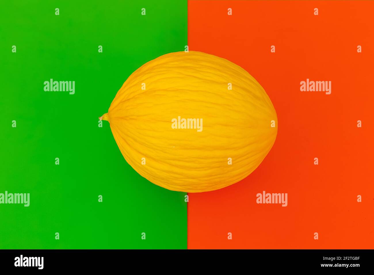 Décoration pop art en melon. Melon jaune sur fond orange et vert à deux tons. Concept alimentaire. Banque D'Images