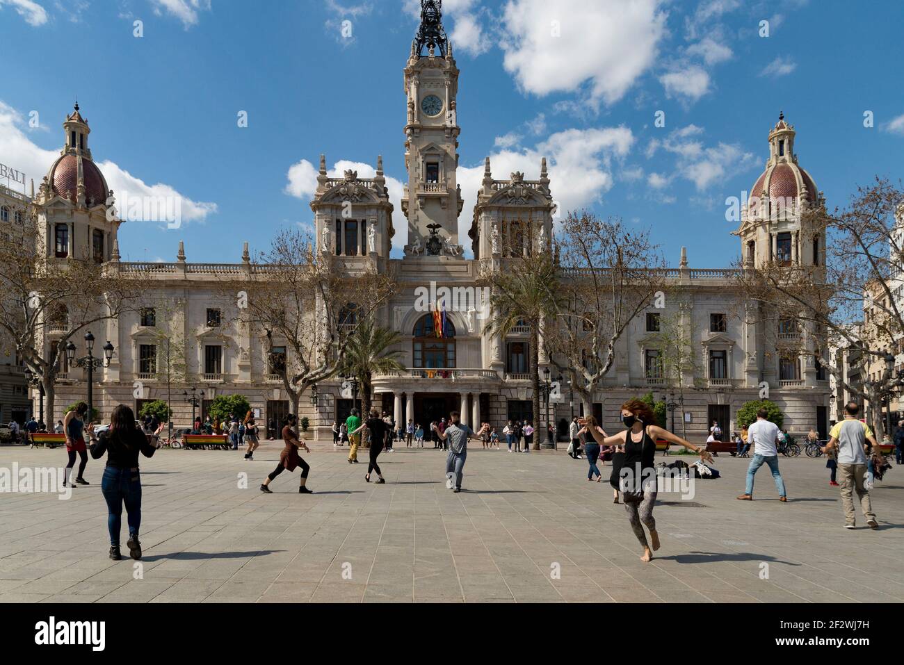 Valence, Espagne. 13 mars 2021. Les personnes portant des masques de visage dansent sur la place de l'hôtel de ville.tous les Fallas Act ont été suspendus en permanence en raison de la situation sanitaire causée par Covid19. Pour se souvenir de l'esprit des Fallas pendant la semaine suivante, un chaudron a été allumé comme un rappel sur la place de l'hôtel de ville de Valence. Crédit : SOPA Images Limited/Alamy Live News Banque D'Images