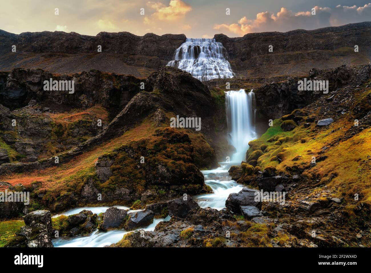 Cascade de Dynjandi avec cascades à plusieurs niveaux au premier plan. Prise de vue au lever du soleil en début de matinée en automne. Exposition longue durée Banque D'Images
