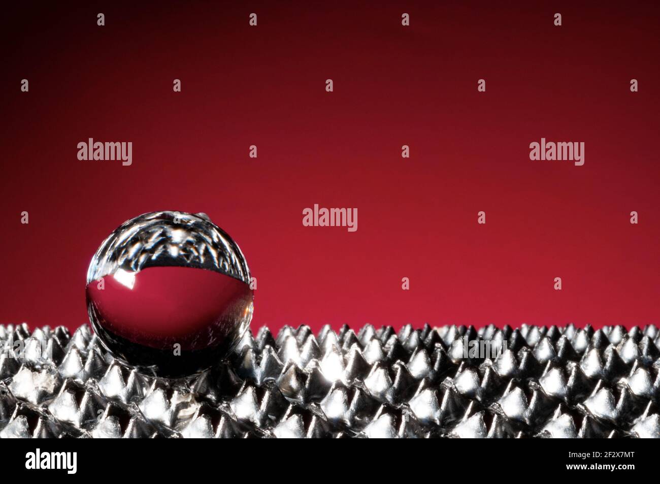 Sphère de verre sur fond rouge clair avec macro d'espace de copie vue Banque D'Images