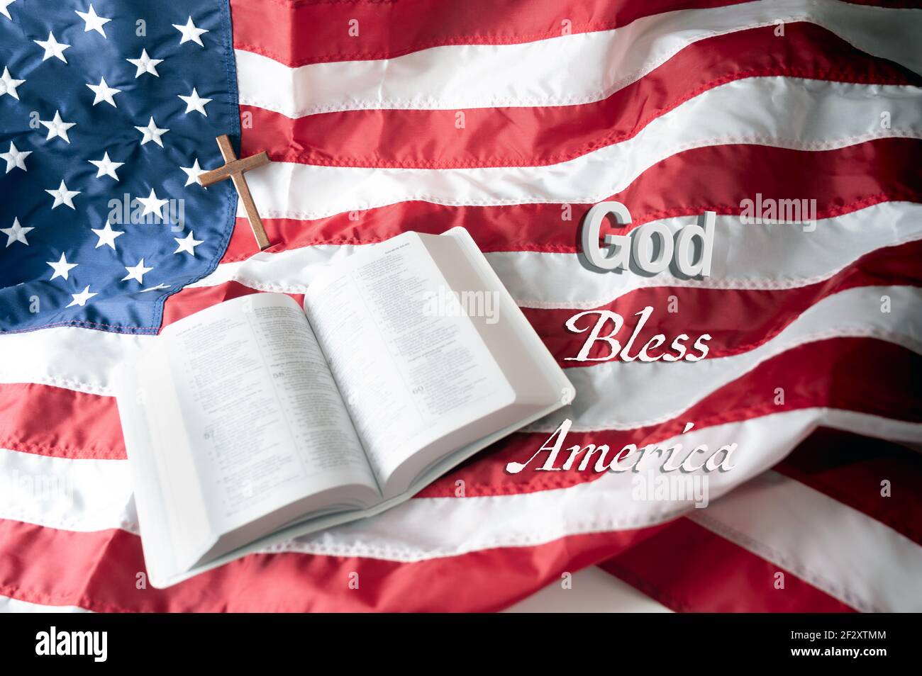 Ouvrez la Sainte bible et la croix en bois sur le fond du drapeau américain. Dieu bénisse l'Amérique. Mise au point élective, espace de copie... Banque D'Images