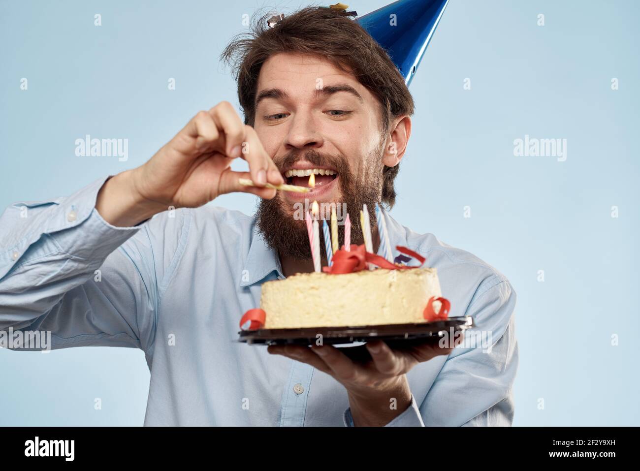 Anniversaire Homme Femme En Chapeaux De Fete Sur Fond Bleu Et Gateau Aux Bougies Photo Stock Alamy