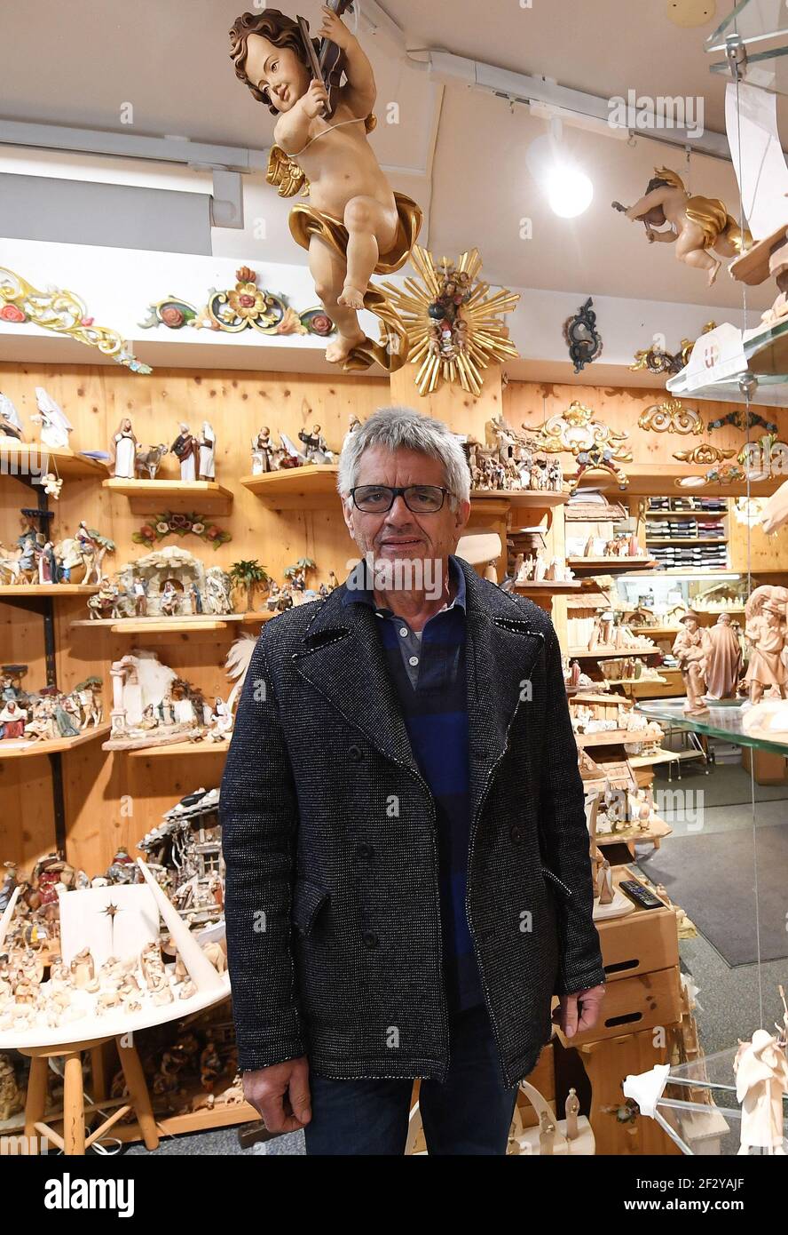 Oberammergau, Allemagne. 17 février 2021. Toni Baur se tient dans son  magasin fermé de sculpture sur bois, qui est richement rempli de scènes de  nativité, de personnages saints et de crucifix. L'affaire