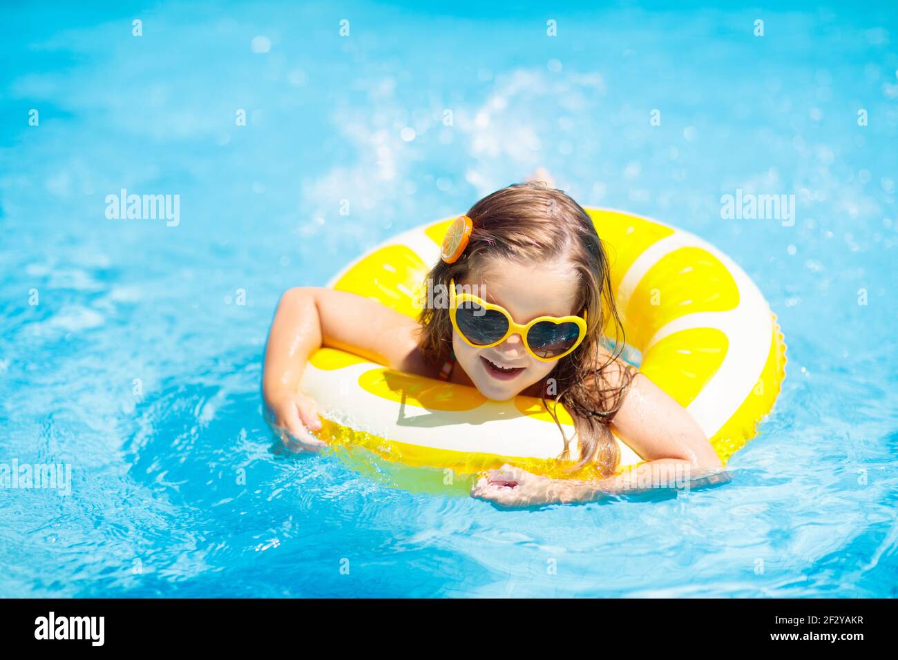Enfant dans une piscine au citron jaune gonflable anneau. Petite fille  apprendre à nager avec flotteur orange. Jouet d'eau pour bébé et d'enfant.  Pis sain Photo Stock - Alamy