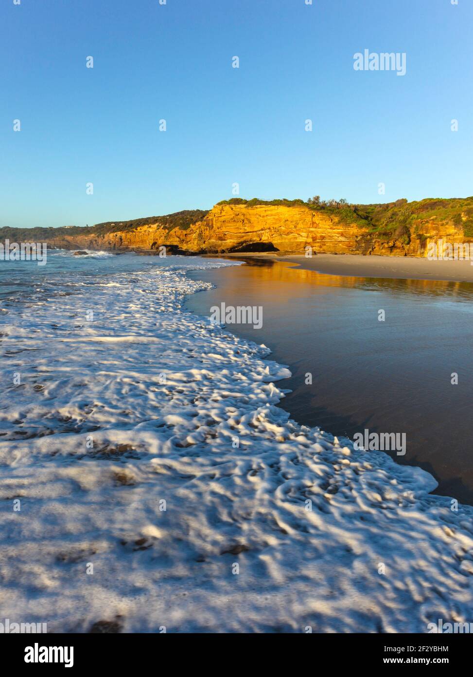 Wave roule sur le sable à Caves Beach au sud de Newcastle - Nouvelle-Galles du Sud Australie Banque D'Images