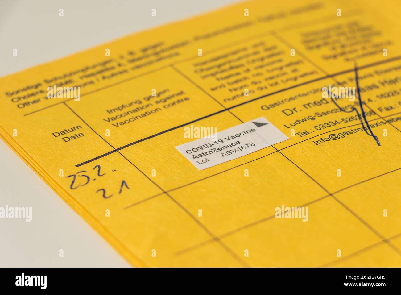 Page de la carte de vaccination avec preuve de vaccination de Corona. Ouvrir le certificat de vaccination jaune de L'OMS avec le certificat de vaccination Banque D'Images Page de la carte de vaccination avec preuve de vaccination de Corona. Ouvrir le certificat de vaccination jaune de L'OMS avec le certificat de vaccination Banque D'Images