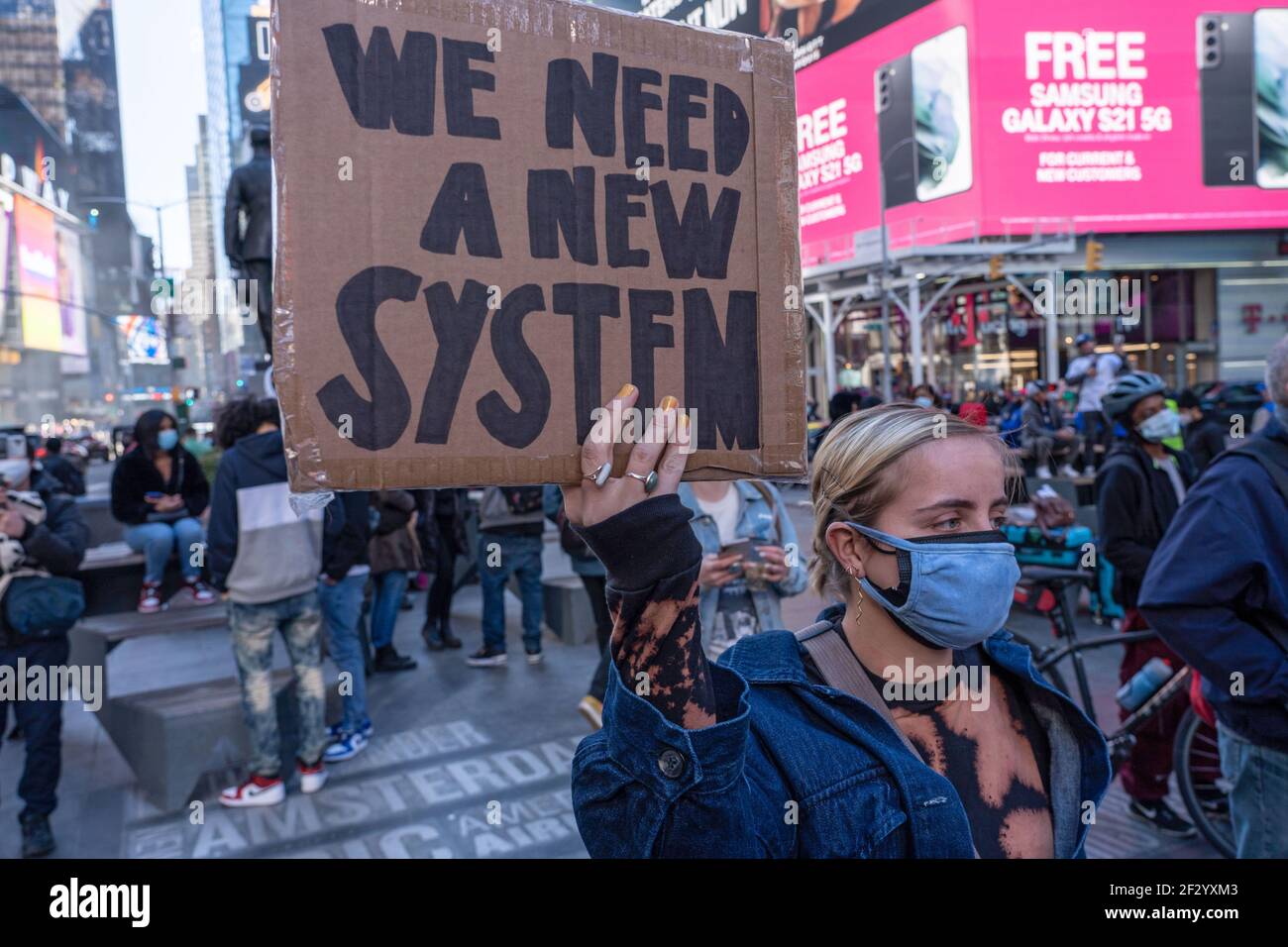 New York, États-Unis. 13 mars 2021. Un manifestant tient un écriteau indiquant que nous avons besoin d'un nouveau système lors d'une manifestation de Breonna Taylor à Times Square à New York.des centaines de personnes se sont rassemblées à Times Square pour se souvenir de Breonna Taylor. Mme Taylor a été tuée par la police du Kentucky de Louisville il y a un an, le 13 mars 2020. Crédit : SOPA Images Limited/Alamy Live News Banque D'Images
