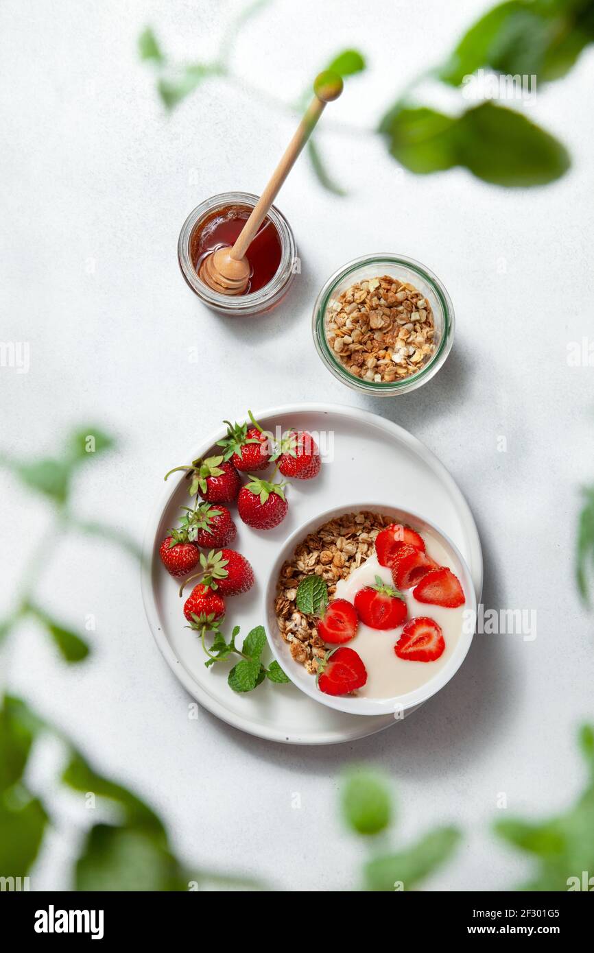 petit déjeuner sain avec granola, yaourt, fraises sur une assiette blanche. vue d'en haut Banque D'Images