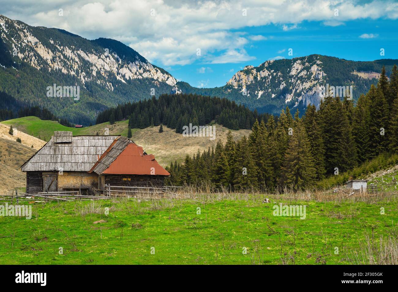 Lieu rural alpin d'été avec cabane en bois de rickety et montagnes Piatra Craiului en arrière-plan, village de Pestera, Transylvanie, Roumanie, Europe Banque D'Images