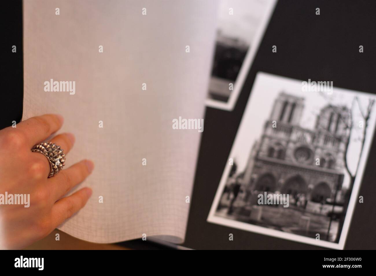 main femelle portant un anneau tournant page d'une photo Album montrant la photo en noir et blanc de Paris notre Dame Église Banque D'Images