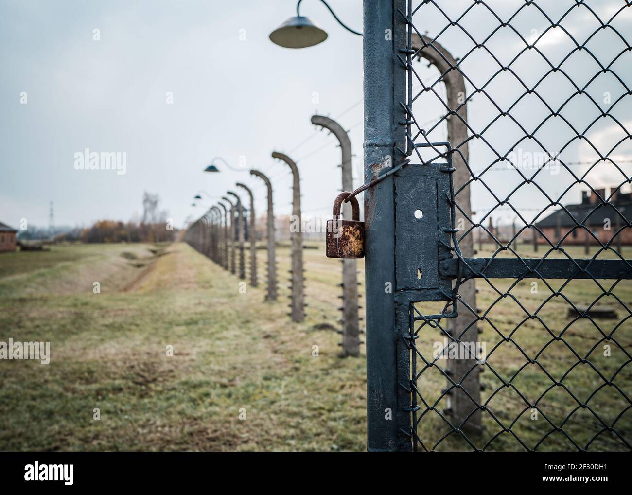 Cadenas et chaîne à la porte de la concentration de la guerre mondiale 2 prisonnier de camp de guerre enfermé avec une barbe électrique haute tension clôture métallique et ancien point de protection rétro Banque D'Images