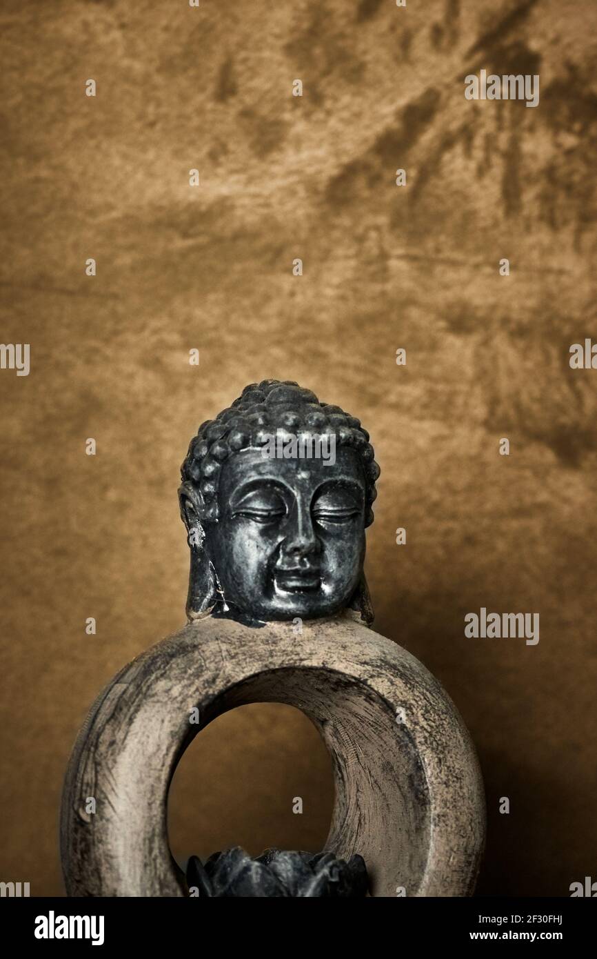 Petite sculpture de Bouddha sur fond de bronze texturé Banque D'Images