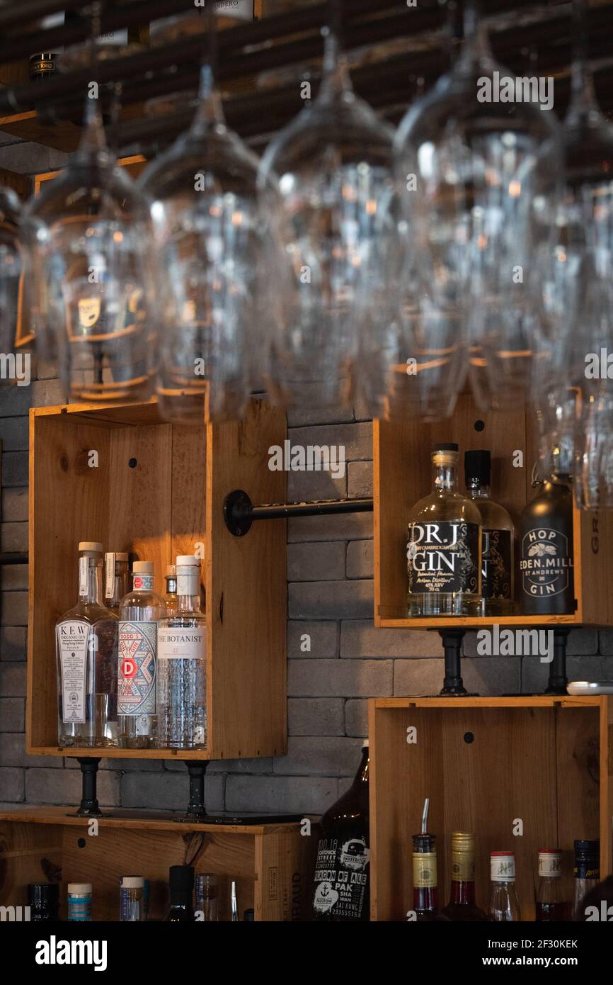 Gros plan du mur de fond d'un comptoir de bar avec bouteilles d'alcool et  verres au premier plan Photo Stock - Alamy