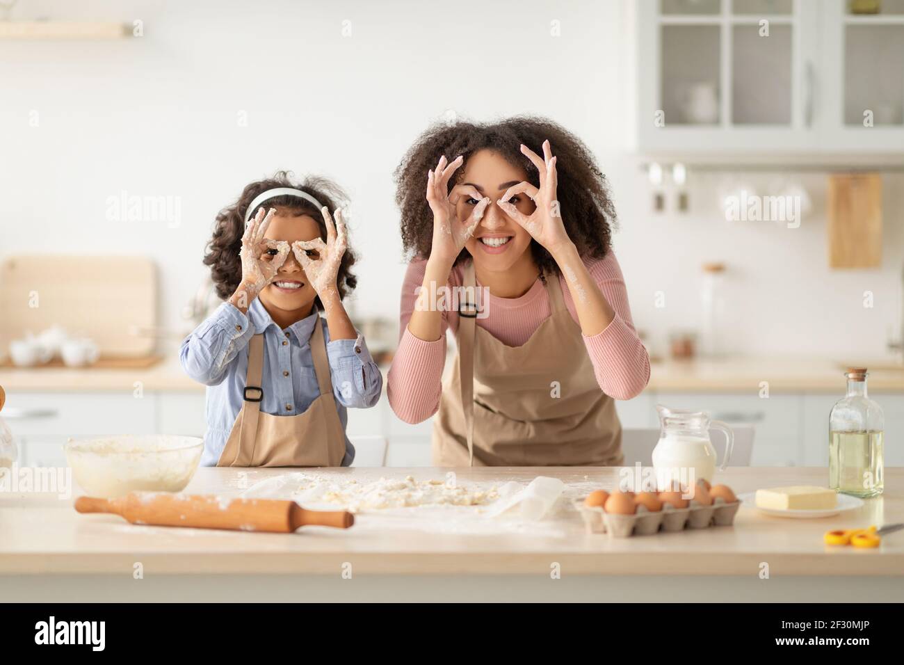 Mère et fille noires jouant dans la cuisine Banque D'Images