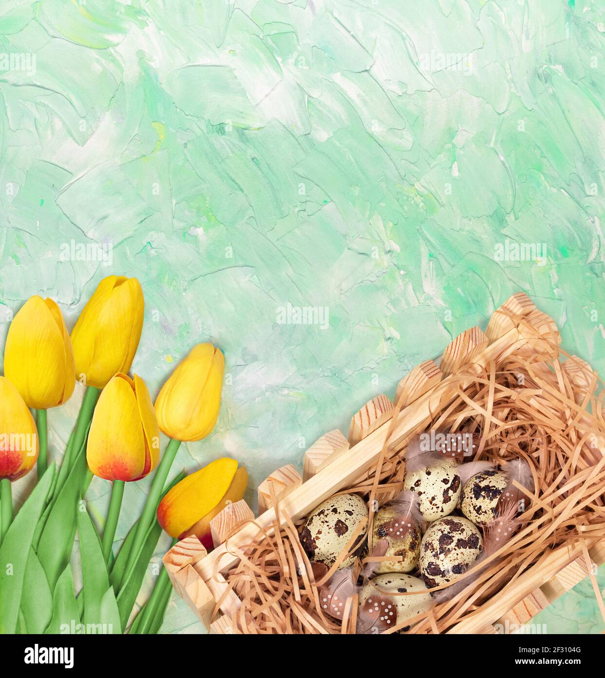 Bouquet de tulipes jaunes et nid avec œufs de caille sur fond vert menthe. Carte postale pour Pâques ou le printemps. Copier l'espace Banque D'Images