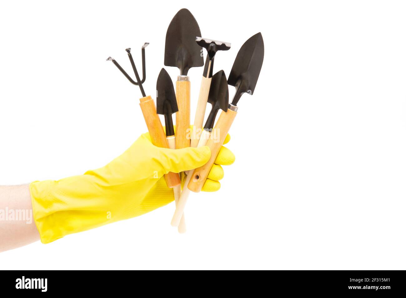 Ensemble d'outils à main de jardin dans une main mâle portant un gant jaune isolé sur fond blanc. Banque D'Images Ensemble d'outils à main de jardin dans une main mâle portant un gant jaune isolé sur fond blanc. Banque D'Images