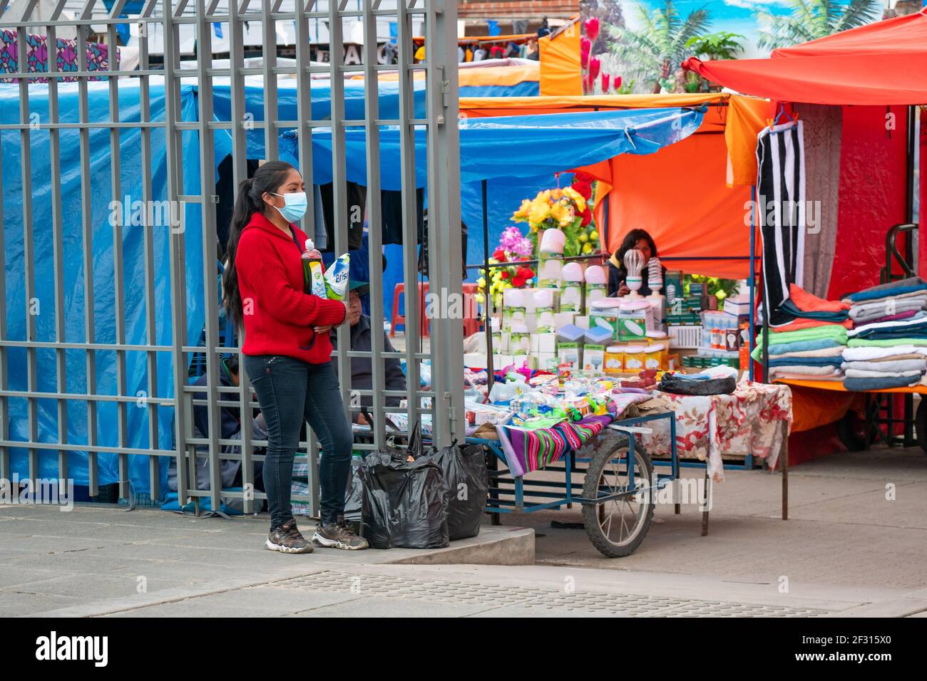 El Alto, la Paz, Bolivie - février 11 2021 : jeune femme indigène bolivienne attendant des produits de nettoyage et des sacs à la porte du câble rouge Banque D'Images