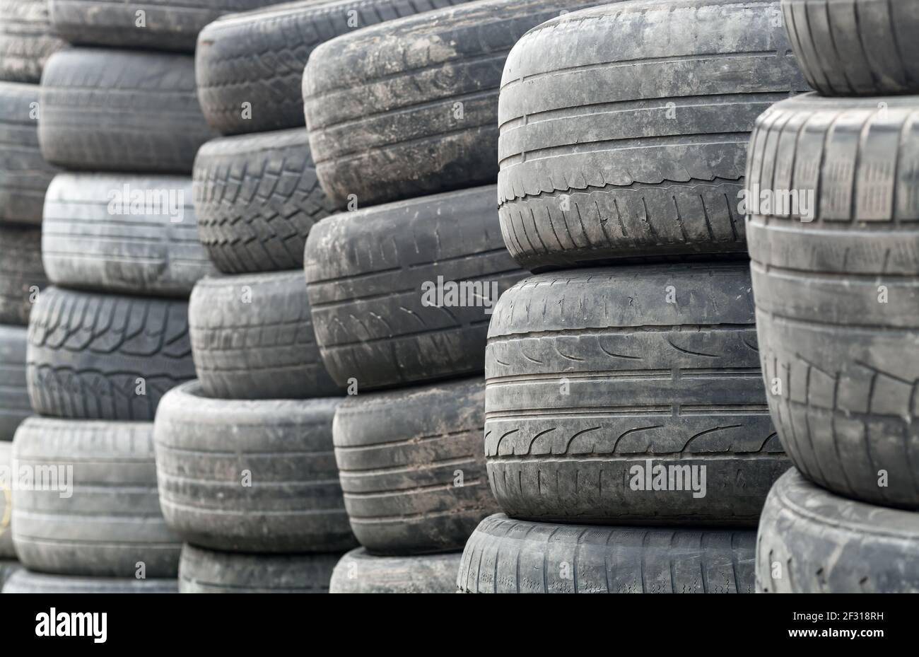 Les pneus de roue usagés sont empilés et prêts à être recyclés Banque D'Images