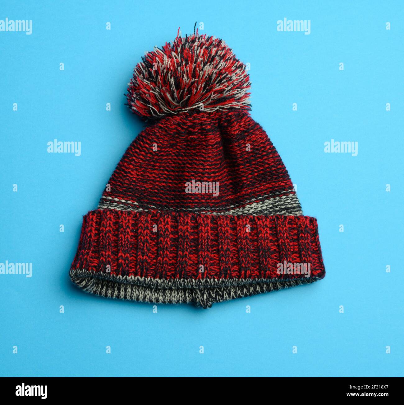 Chapeau Tricoté Rouge-Noir Avec Pompon Sur Fond Bleu Photo Stock - Alamy