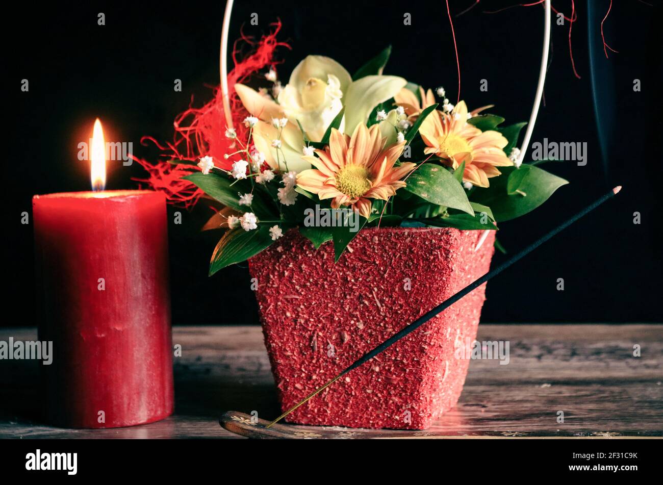 Bougie rouge, fleurs et bâton parfumé Banque D'Images