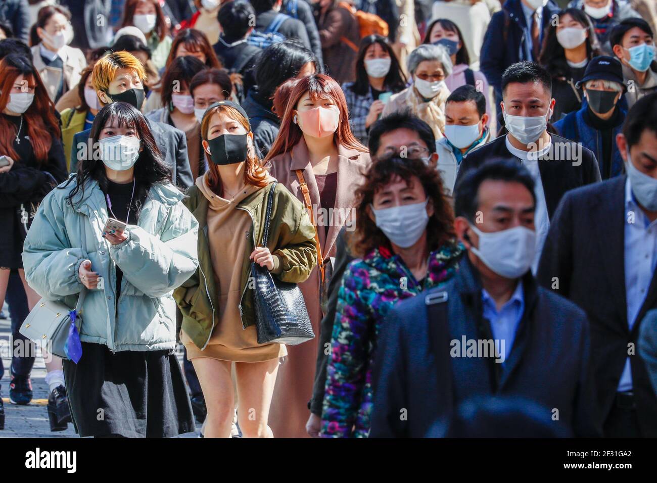 Les personnes portant des masques de visage comme mesure préventive contre la propagation de covid-19 traversent la célèbre intersection de broussaires près de la station de Shibuya. Le gouvernement japonais s'est penché vers la fin de l'état d'urgence pour Tokyo et les régions environnantes au-dessus de COVID-19 comme prévu le 21 mars, a rapporté le journal dimanche. Banque D'Images