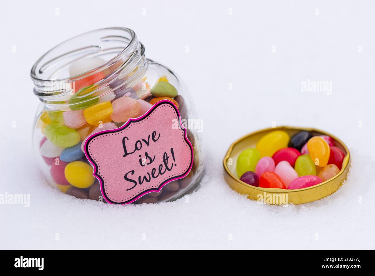 Jelly beans colorés dans un pot isolé sur blanc. Banque D'Images