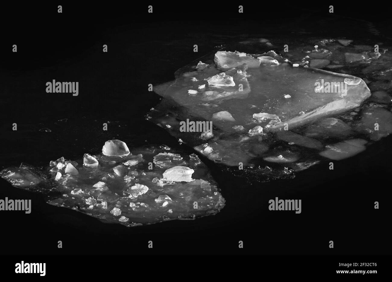 De magnifiques floes de glace dans l'eau sombre noir et blanc photo Banque D'Images