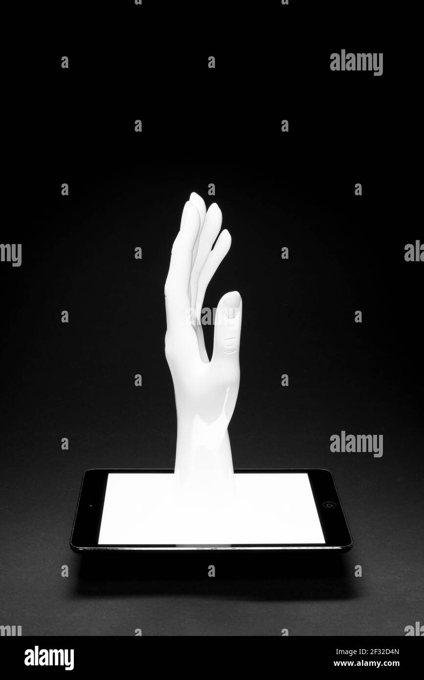 Main sortant d'un écran de tablette Banque D'Images