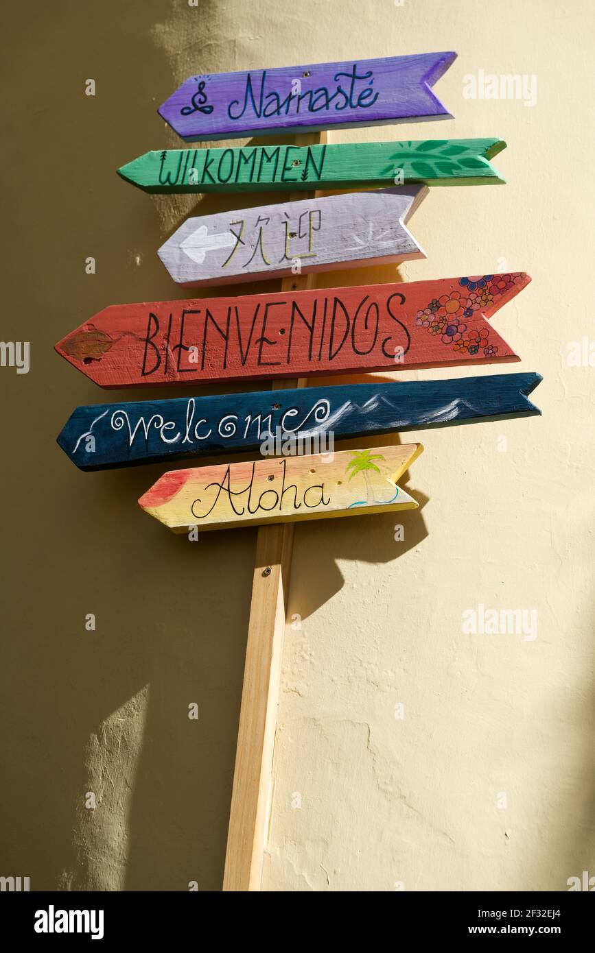 Bienvenue signe dans différentes langues devant un jaune mur Banque D'Images