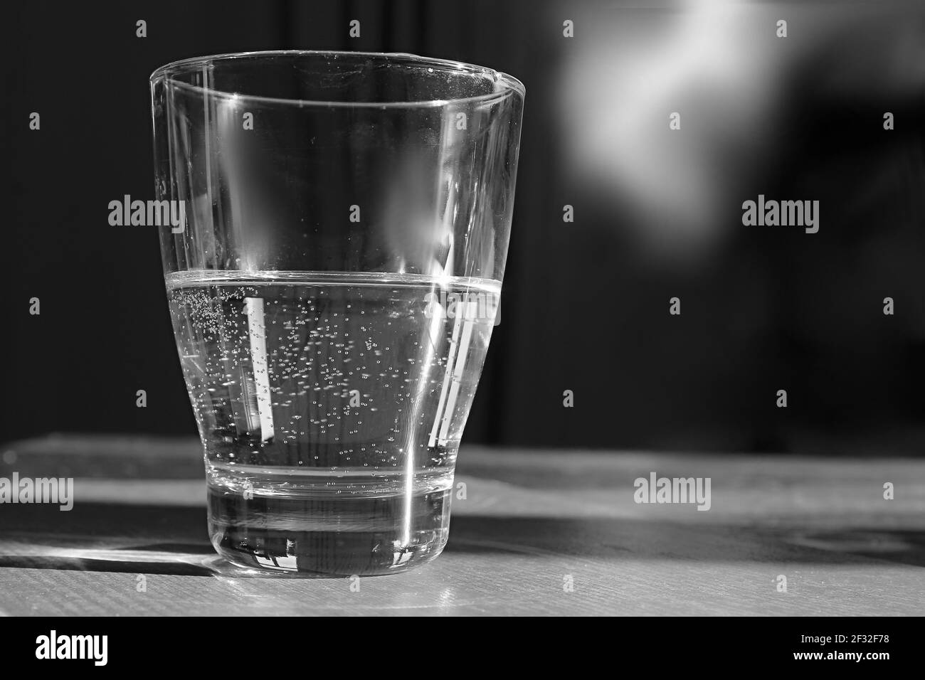 verre d'eau claire et froide posé sur une table en noir et photo de stock blanche Banque D'Images