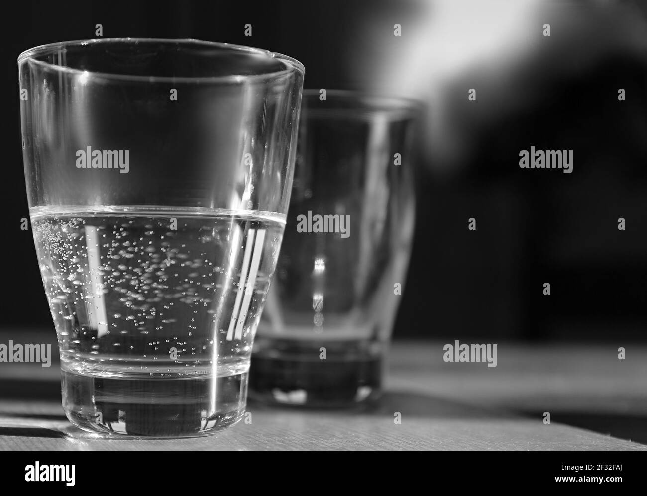 verre d'eau claire et froide posé sur une table en noir et photo de stock blanche Banque D'Images