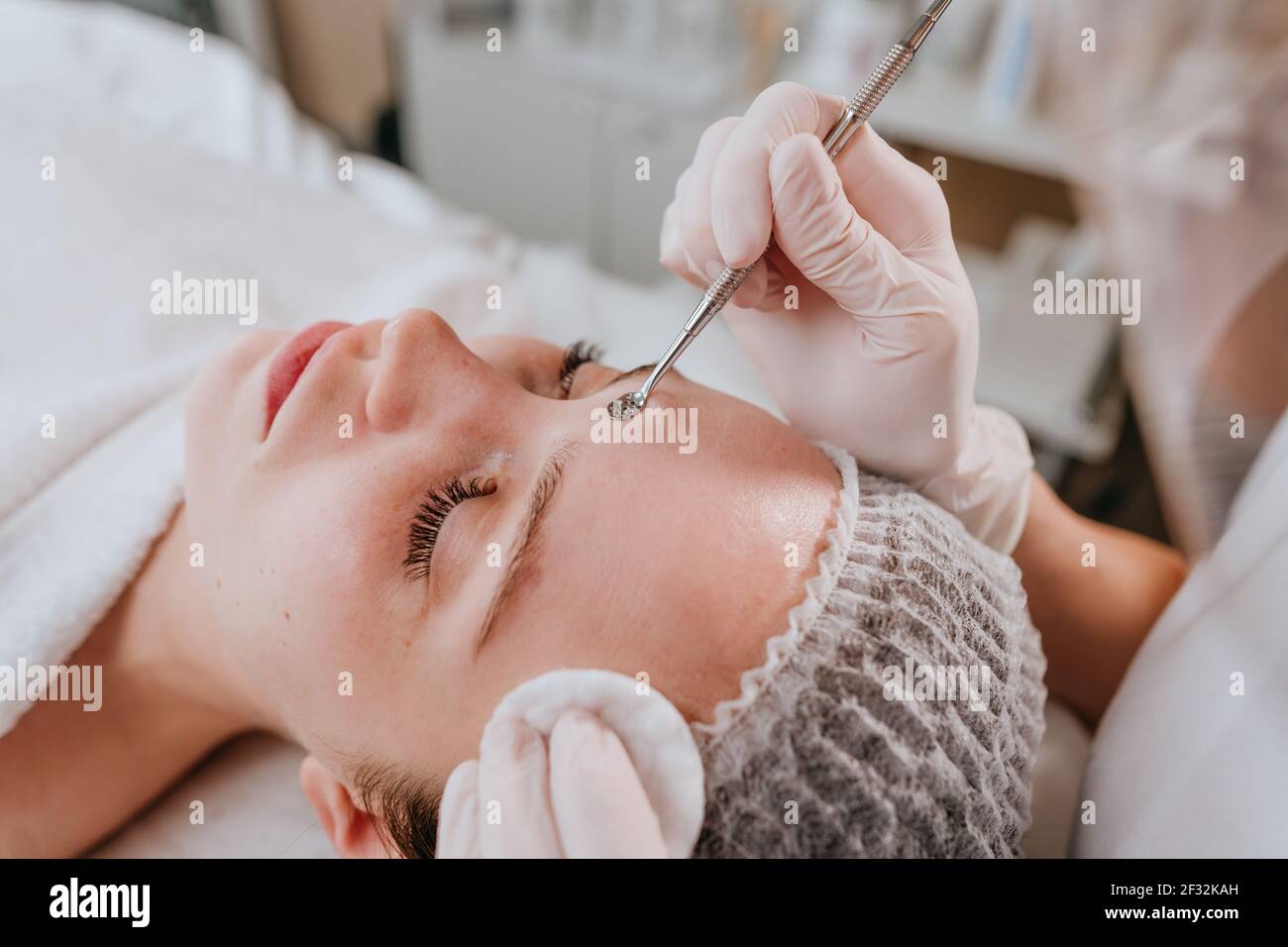 Gros plan d'un esthéticien faisant la procédure de nettoyage du visage dans un salon de beauté Banque D'Images