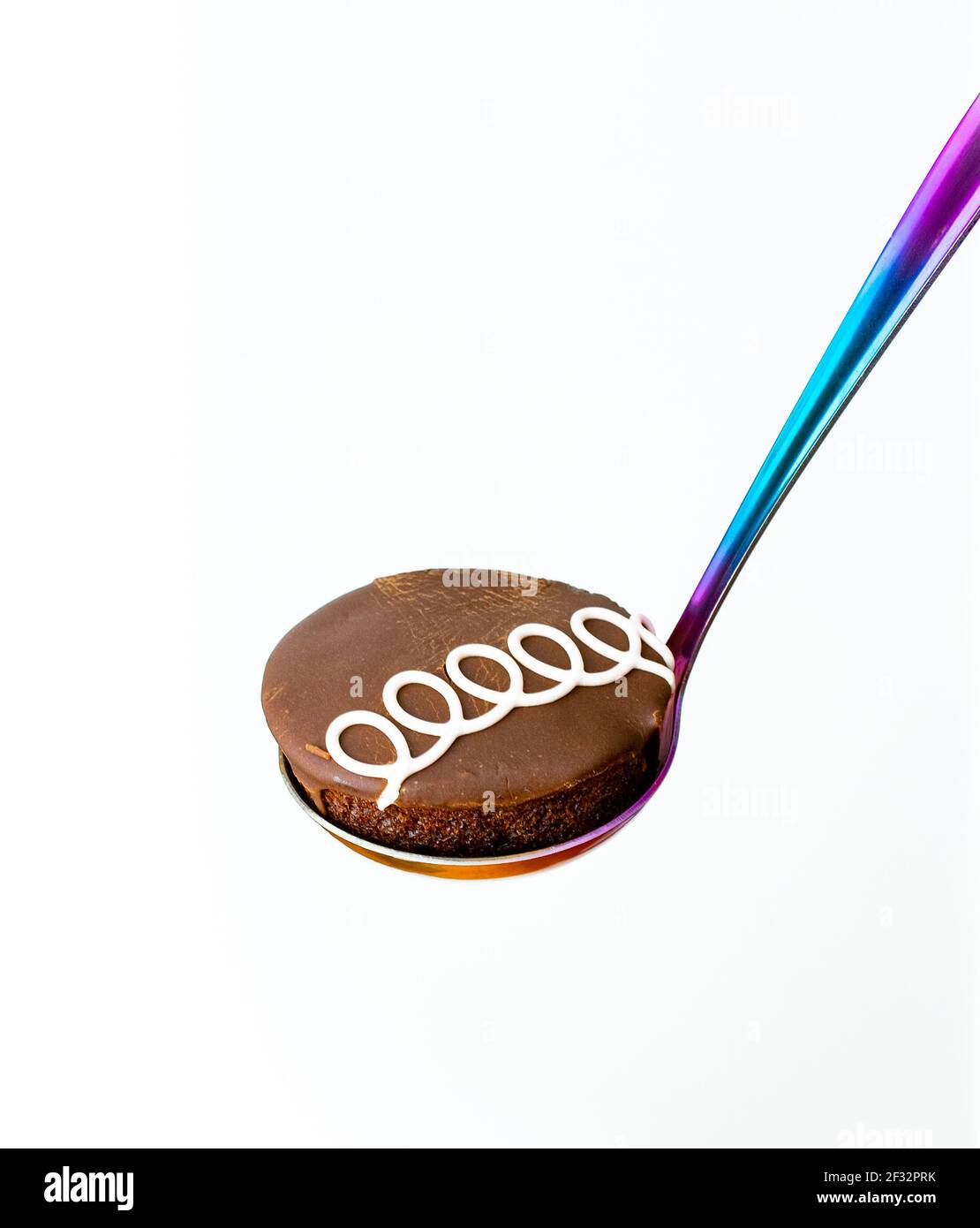 Cupcake au chocolat sur une cuillère colorée avec fond blanc Banque D'Images