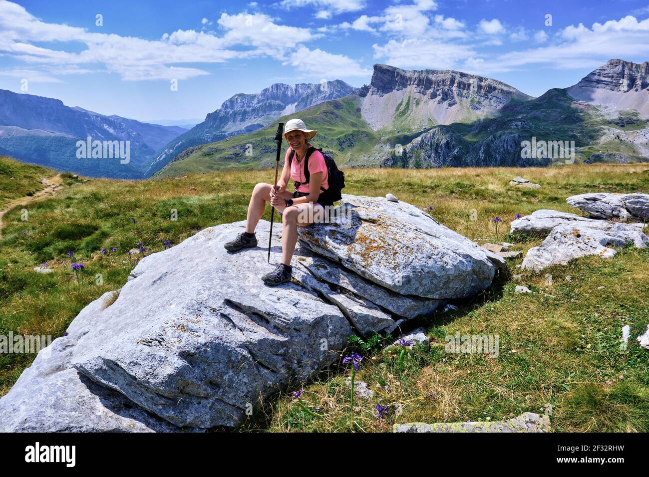 Femme de randonnée dans un paysage de montagnes et de prairies. Banque D'Images