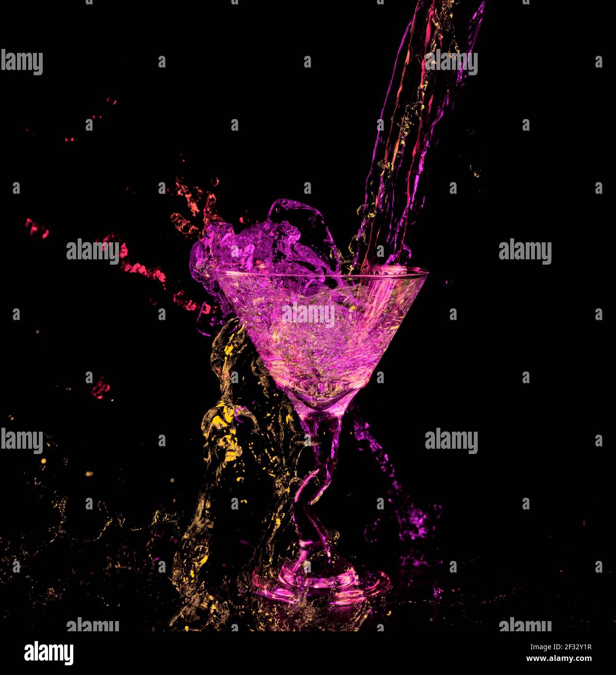 Verre à Martini avec une touche de couleur au néon violet rouge vert jaune fluo couleurs Banque D'Images