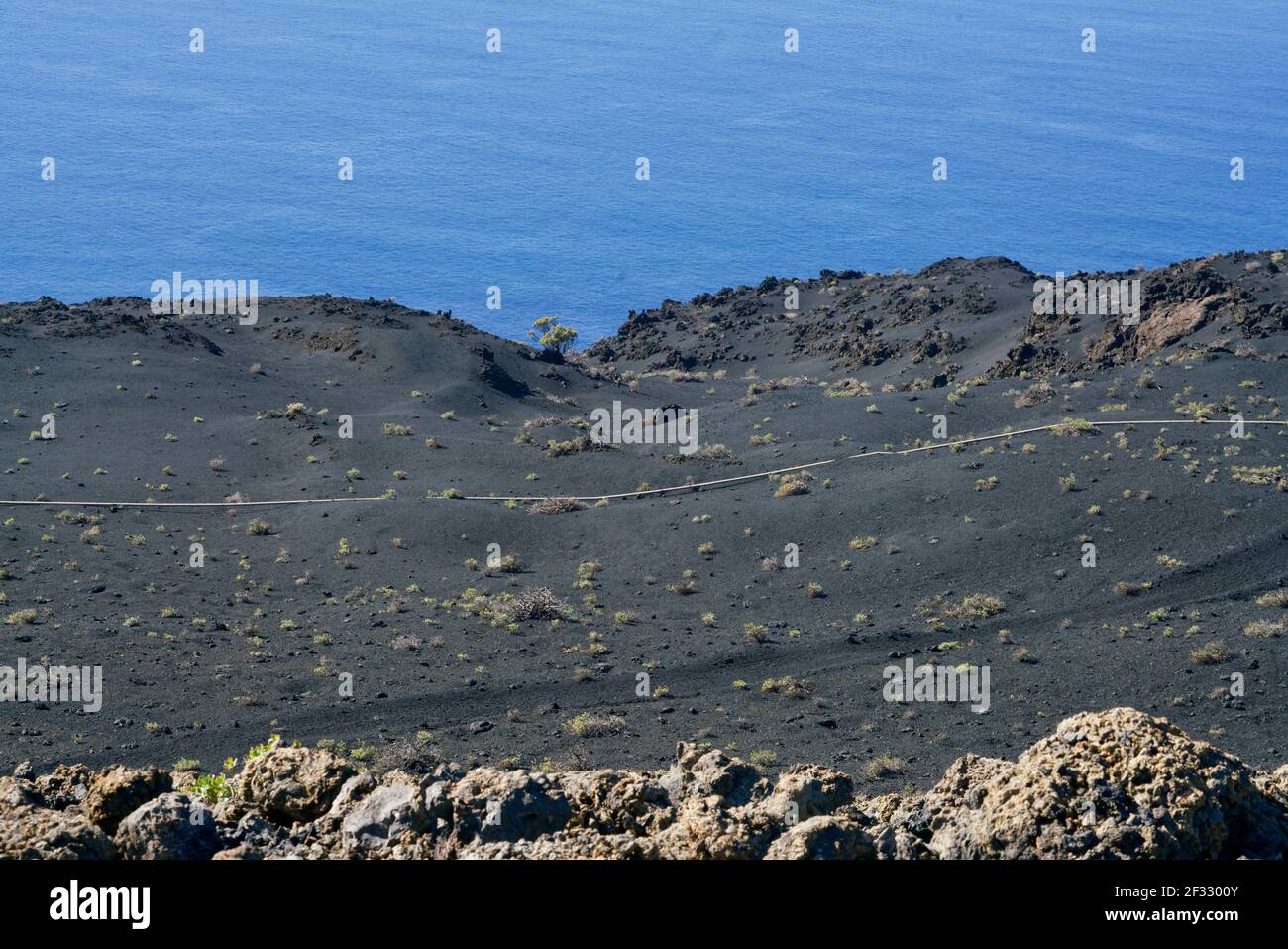 Roche de lave noire sur la mer bleue de la Palma Banque D'Images