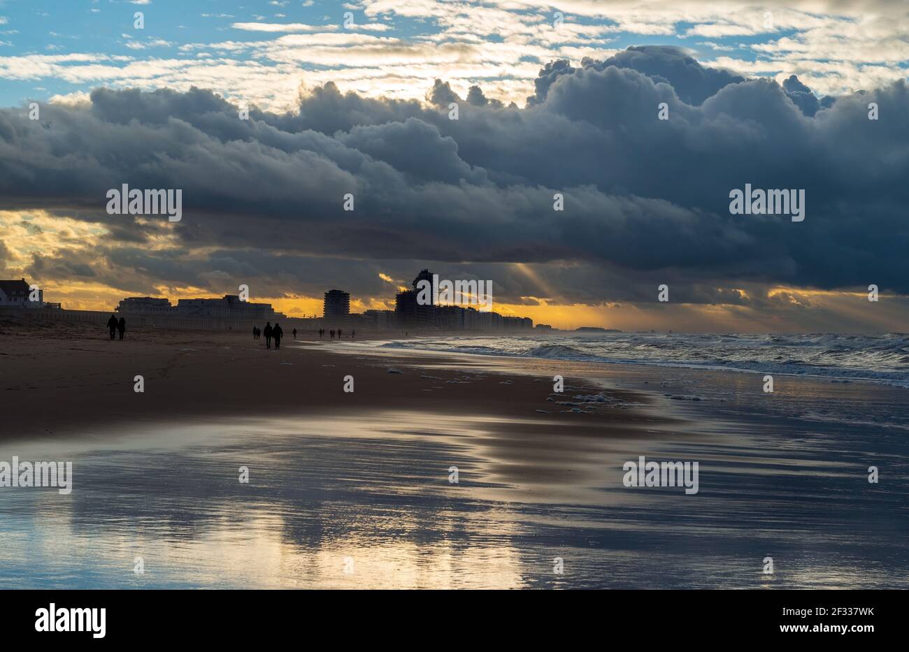 Oostende (Ostende) plage avec temps de tempête et silhouette de gens marchant au bord de la mer du Nord, Belgique. Banque D'Images