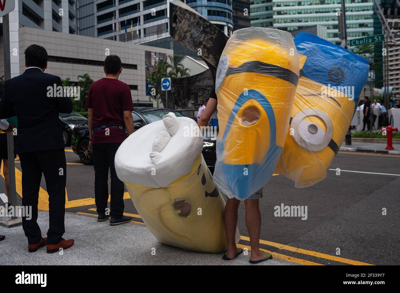 23.08.2018, Singapour, République de Singapour, Asie - UN homme portant des costumes à moitié de corps des personnages du film d'animation 3D Minions attend sur une route. Banque D'Images